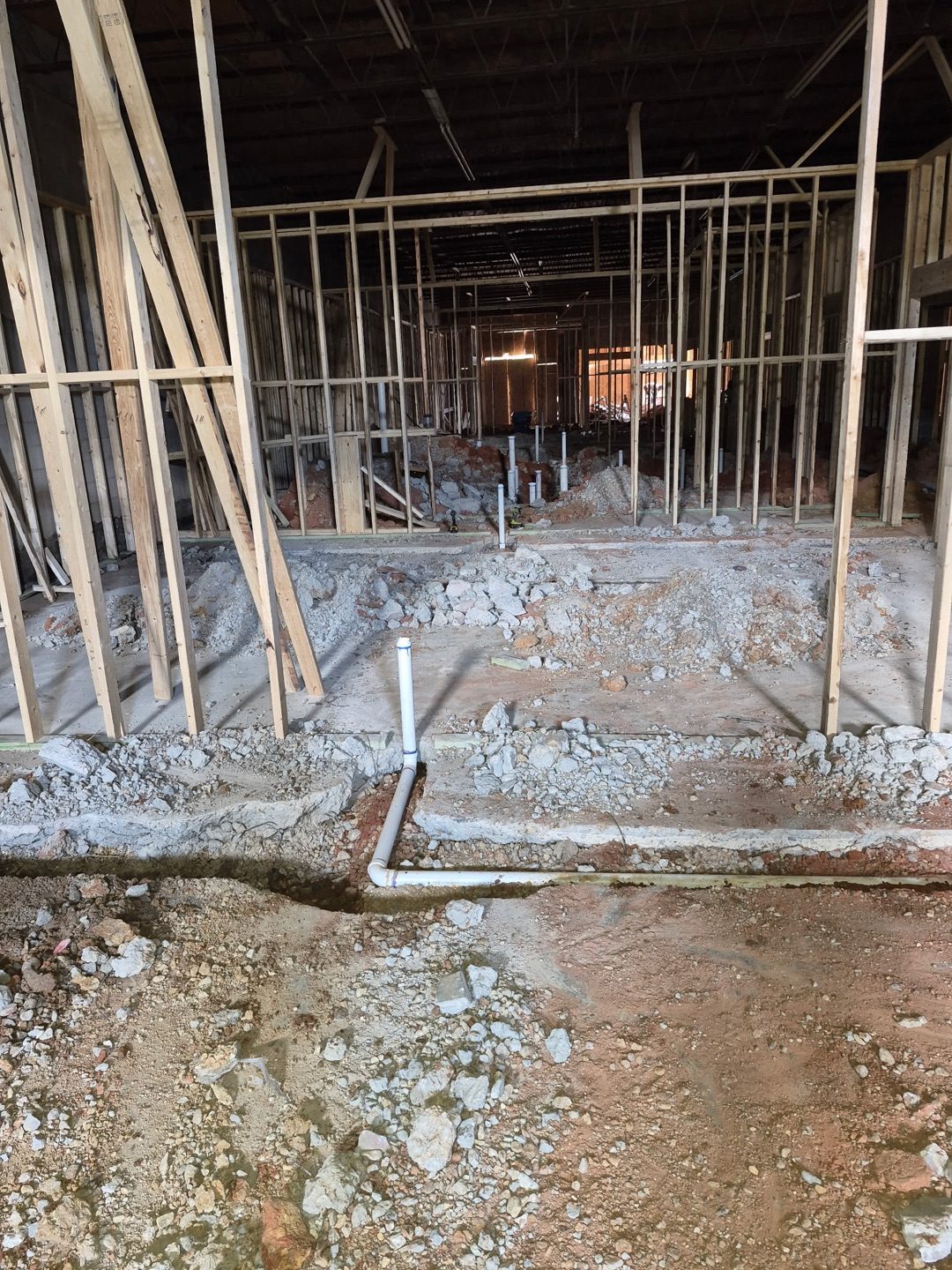 Multi-room building under construction with plumbing stub-ups