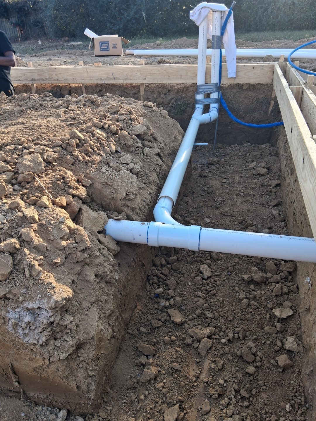 PVC pipe in trench with wooden slab forms